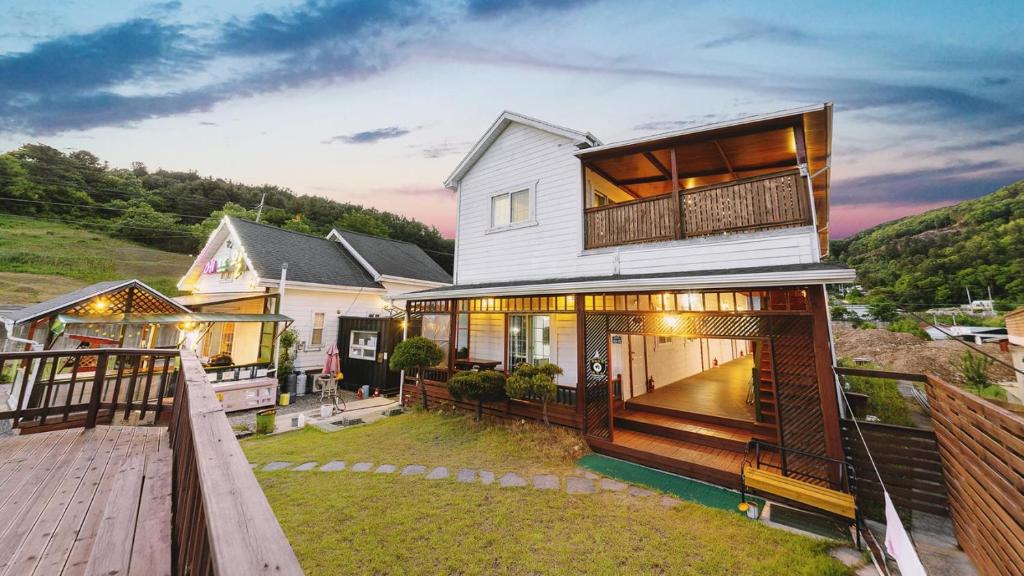 a house with a balcony and a wooden deck at Gapyeong Etoile Pension in Gapyeong