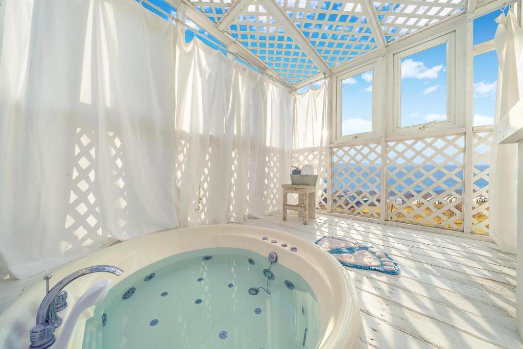 een badkamer met een bad in een kamer met ramen bij Ganghwa Vintage Box Pension in Incheon