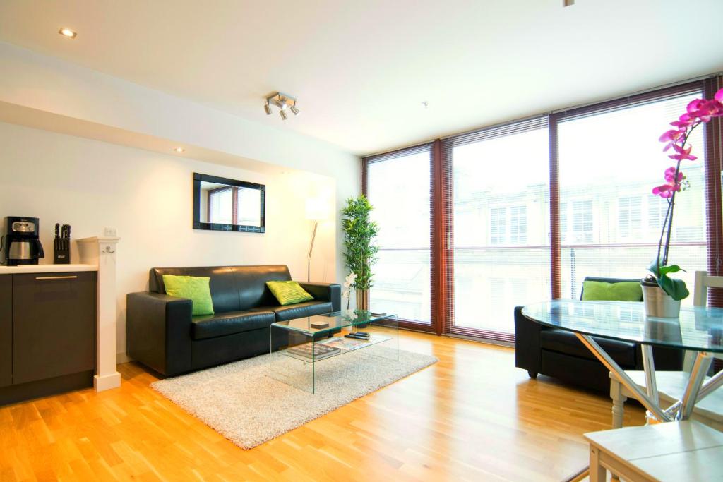 a living room with a couch and a glass table at Mitchell Street Glasgow Apartment in Glasgow