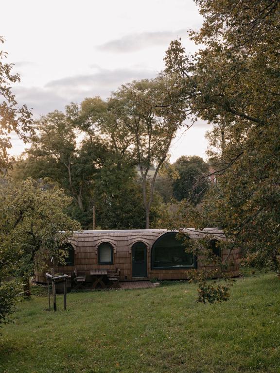 a brick caravan in a field with trees in the background at Stall & Sterne - Tiny Häuser in Hirschfeld