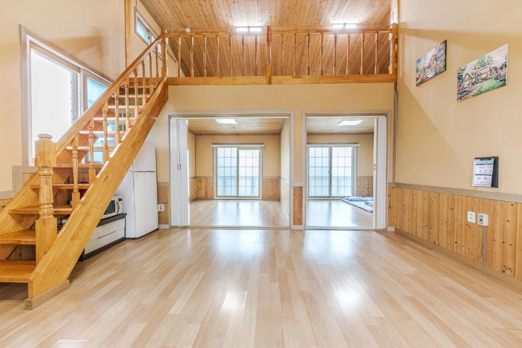 an empty room with a wooden staircase in a house at Suncheonman Muhan Dojan Pension in Suncheon