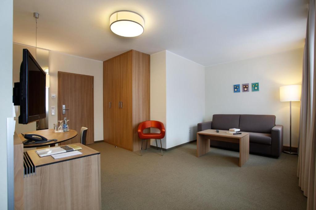 a living room with a couch and a tv at Hotel am Jakobsmarkt in Nuremberg