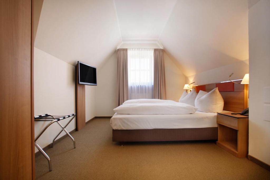 a hotel room with a bed and a television at Hotel am Jakobsmarkt in Nuremberg