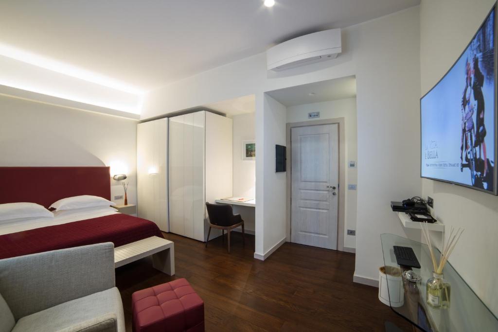レッジョ・ディ・カラブリアにあるTown House Morganaのベッドとデスクが備わるホテルルームです。