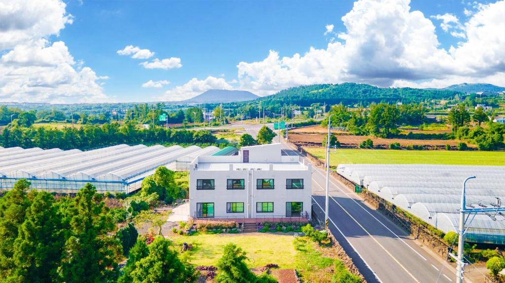 una vista aerea di un grande edificio bianco di Jeju ChunJaNe Pension a Seogwipo