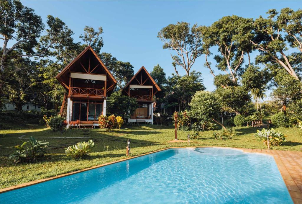 una villa con piscina frente a una casa en Phayamas Private Beach Resort and Island Brew - Adults Only, en Ko Phayam