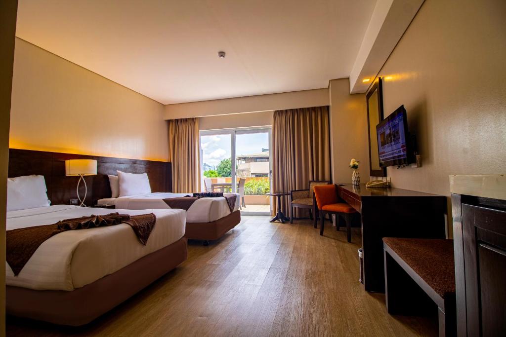 Postel nebo postele na pokoji v ubytování Harolds Hotel Cebu