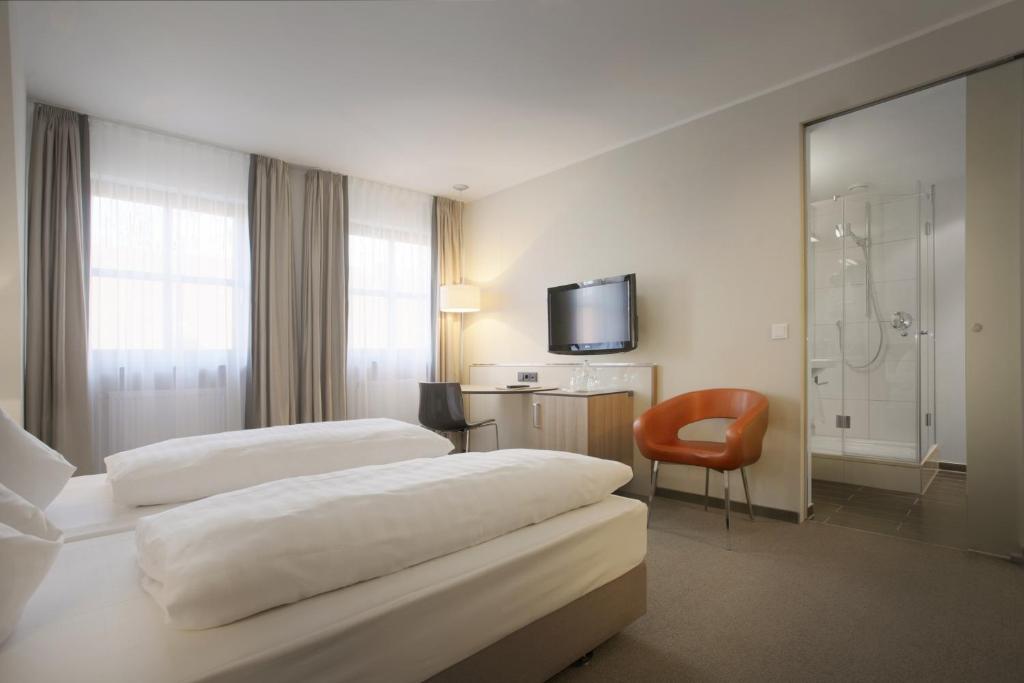 a hotel room with two beds and a television at Hotel am Jakobsmarkt in Nuremberg