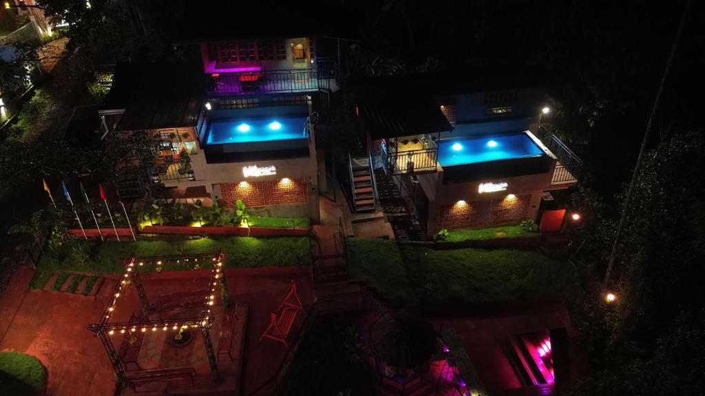 un edificio con luces azules por la noche en Mannath Private Pool Villas at Vellarimala, en Wayanad