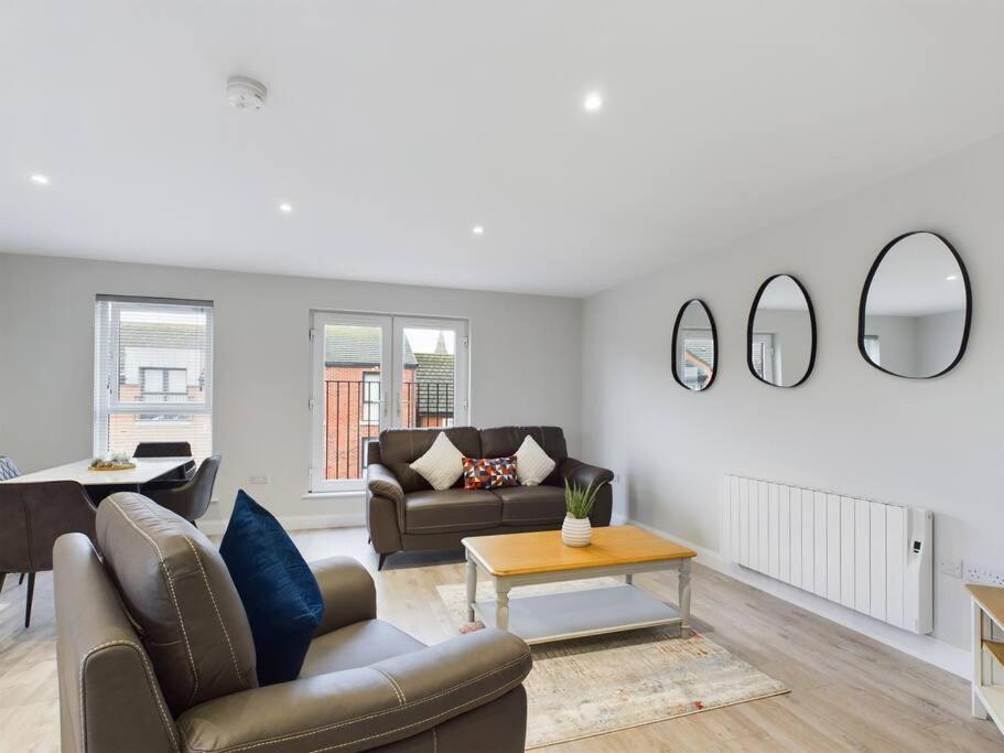 a living room with a couch and a table and mirrors at Cozy 2-Bed Belfast Apartment in Belfast