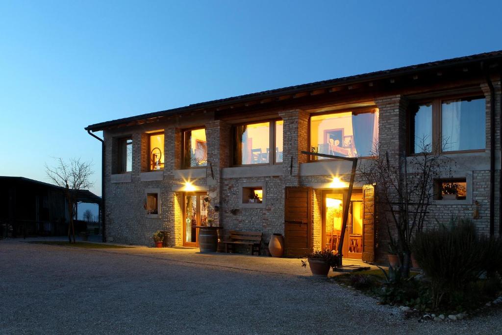 ein großes Backsteinhaus mit eingeschaltetem Licht in der Unterkunft Agriturismo Richeton in Gaiarine