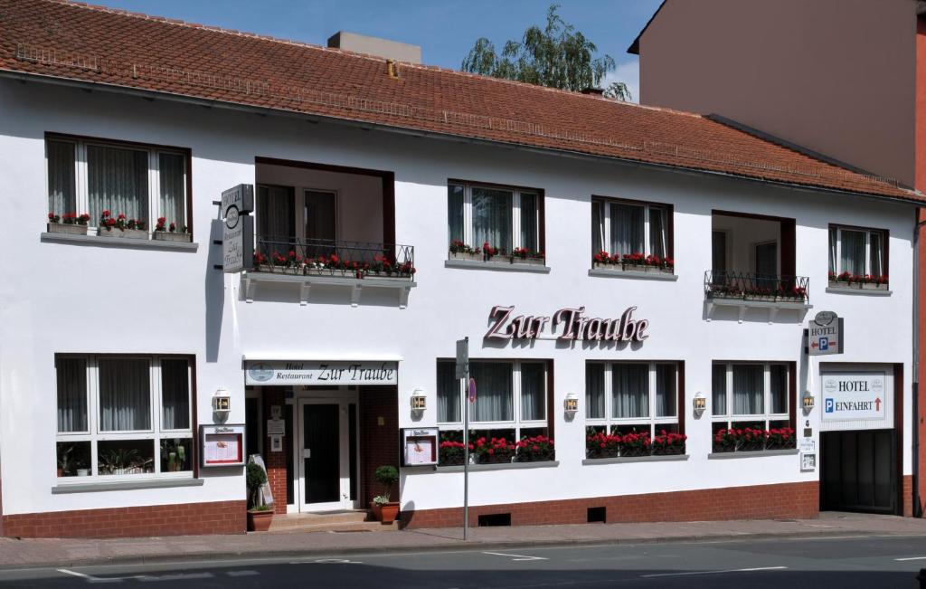 um grande edifício branco com flores nas janelas em Hotel Zur Traube em Bad Homburg vor der Höhe