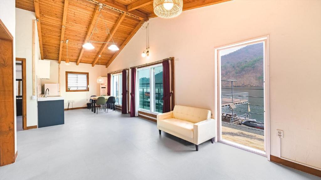 a living room with a large window and a couch at Gapyeong leupuang pension in Gapyeong