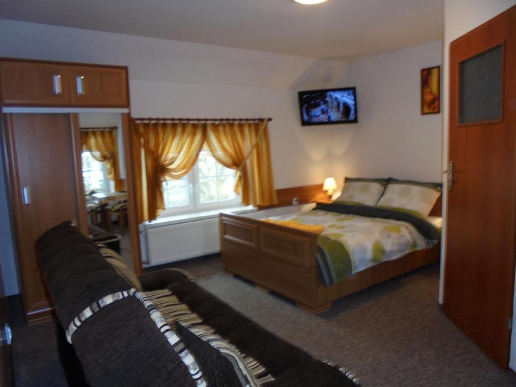 - une chambre avec un lit et un canapé dans l'établissement Agroturystyka Krysia Pilszcz, à Pilszcz