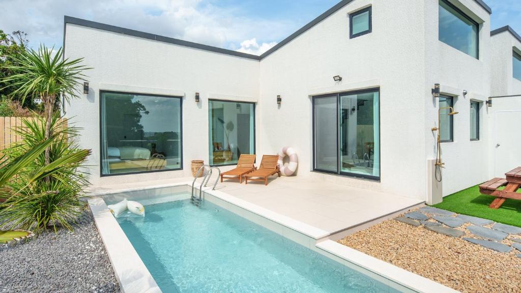 a house with a swimming pool in the yard at Jeju stay eden Dokche poolvila Pension in Seogwipo