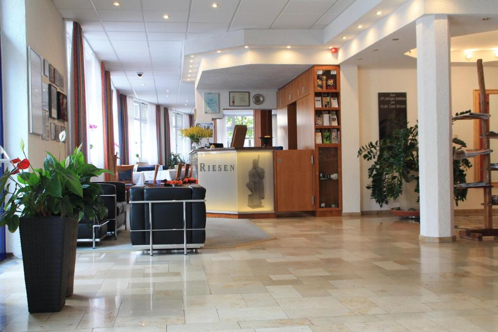 eine Lobby eines Ladens mit einer Rezeption und Pflanzen in der Unterkunft RIESENjunior Hanau by Trip Inn in Hanau am Main