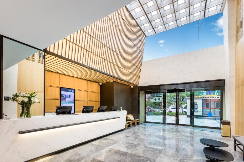 拉萨拉萨布达拉宫广场亚朵酒店的一个带椅子和大窗户的空大堂