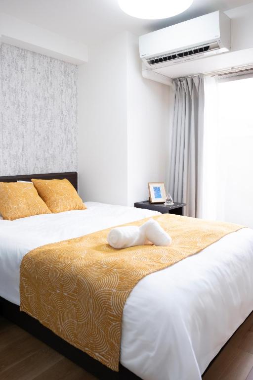 a bedroom with two beds and a air conditioner at The Peak Tengachaya in Osaka