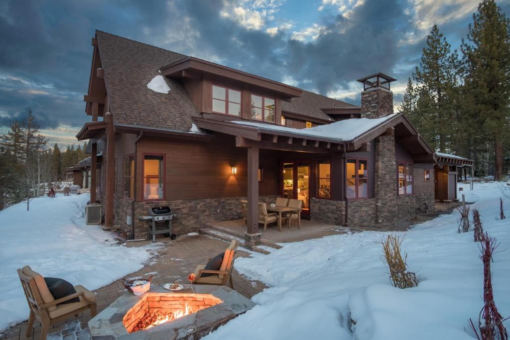 una casa di tronchi con buca per il fuoco nella neve di Maple by AvantStay Modern Mountain Home w Cozy Fire Pit 15 Mins frm Northstar a Ponderosa Fairway Estates