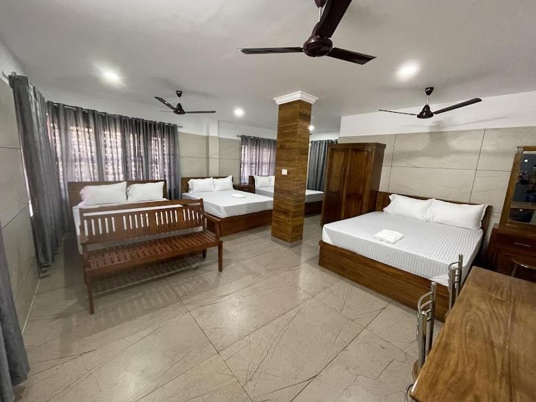 a large room with two beds and a couch at Royal Residency Payyanur in Payyannūr