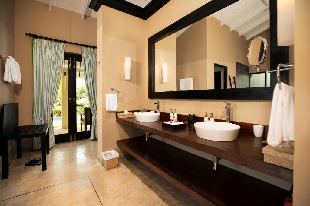 a bathroom with two sinks and a large mirror at Kahanda Kanda in Koggala