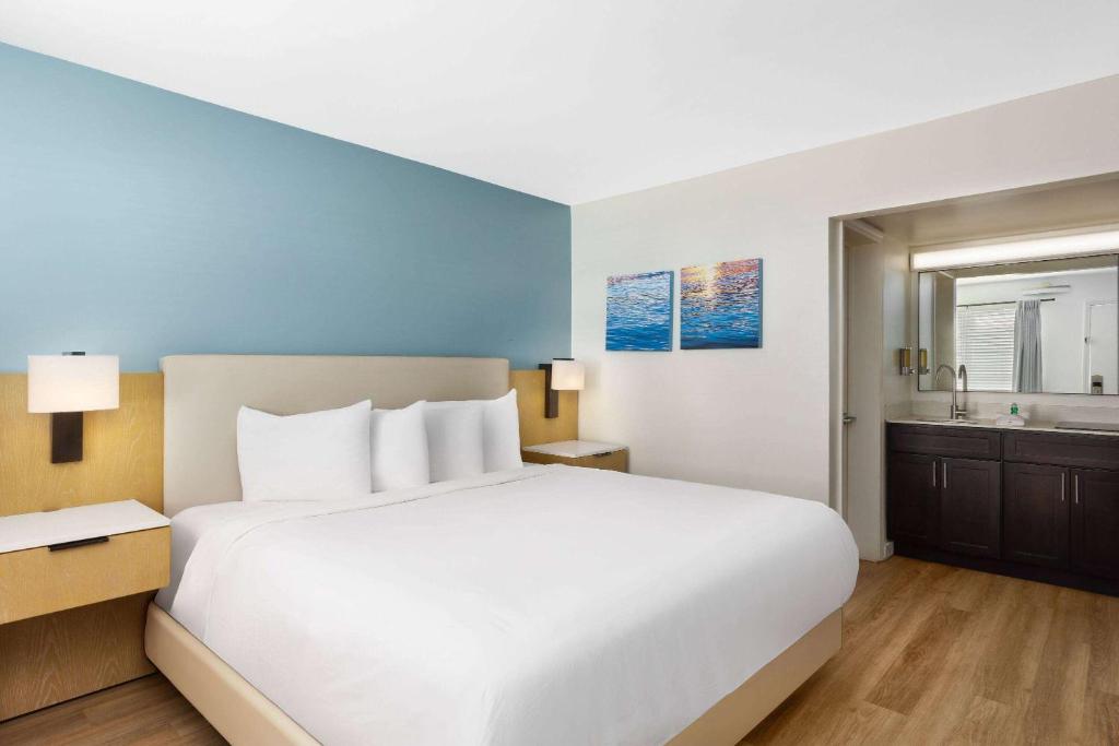 ein Schlafzimmer mit einem großen weißen Bett und ein Badezimmer in der Unterkunft Hotel Manteo, Trademark Collection by Wyndham in Manteo