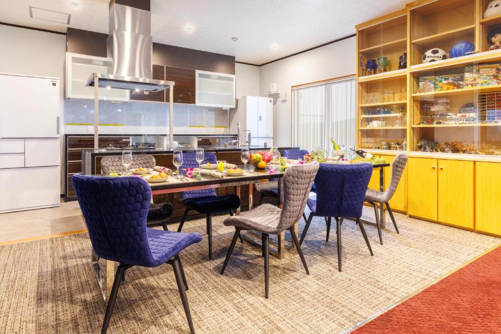 cocina con mesa de comedor y sillas en BBQ可能 露天風呂付き 麻雀 ビリヤード 卓球も可能な最大12名の一棟貸し KOEI HOUSE in KANNA, en Ginoza