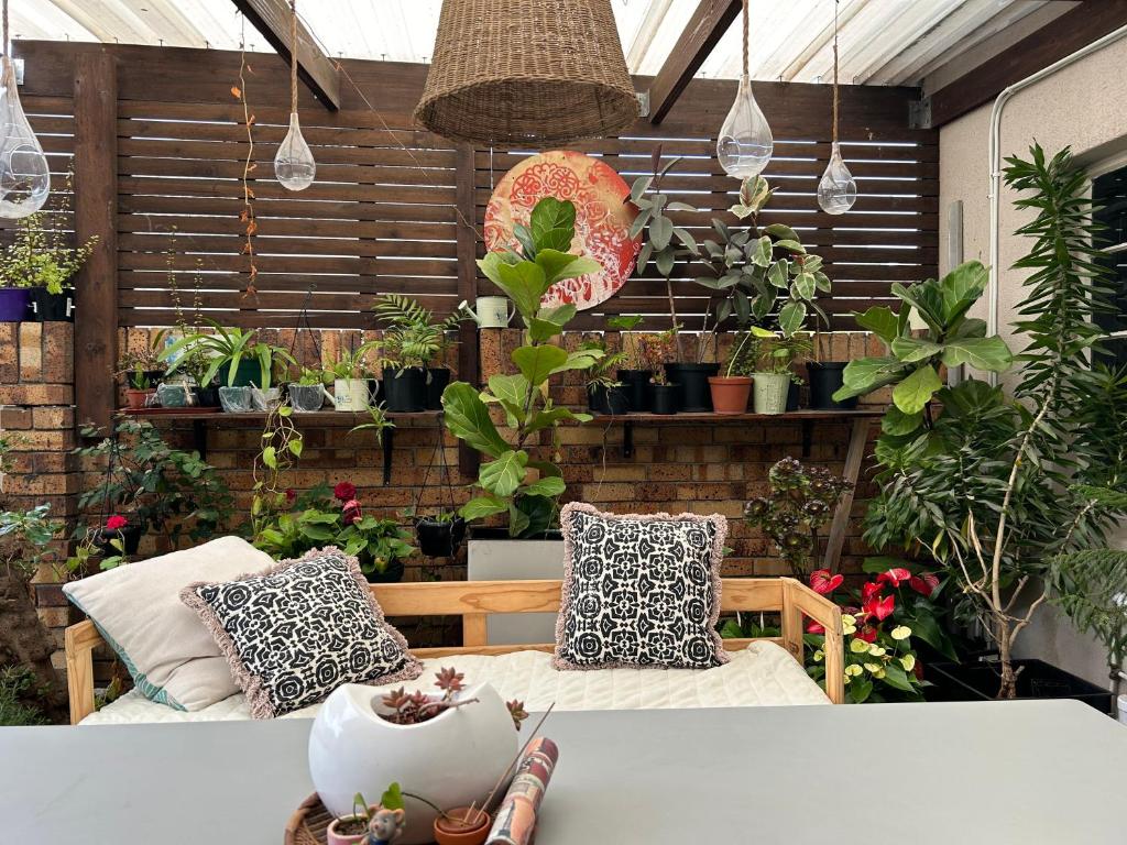 a patio with a table and chairs and potted plants at La Casetta, Garden Retreat in Cape Town