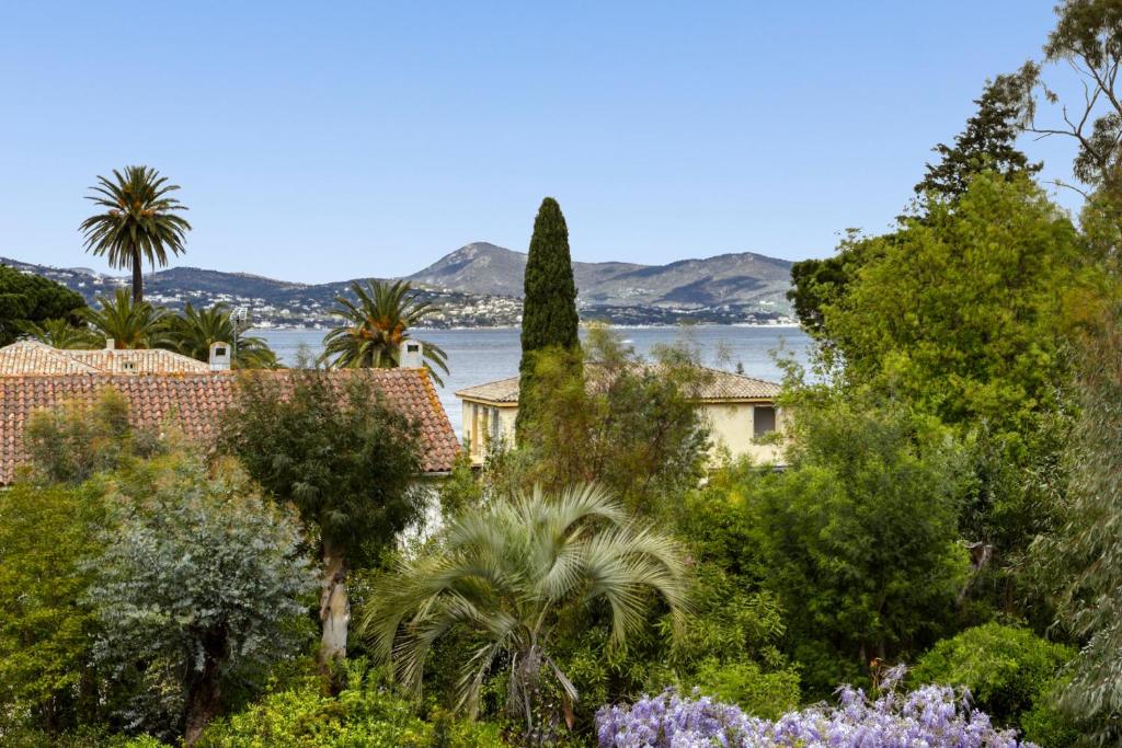 widok na wodę z ogrodu z drzewami w obiekcie 3 Rooms with Sea View Terraces in Peace w Saint-Tropez