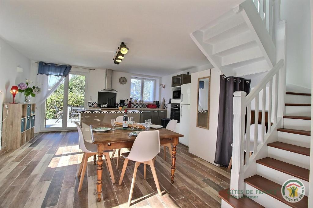 a kitchen and dining room with a table and chairs at Les camelias in Plouézec
