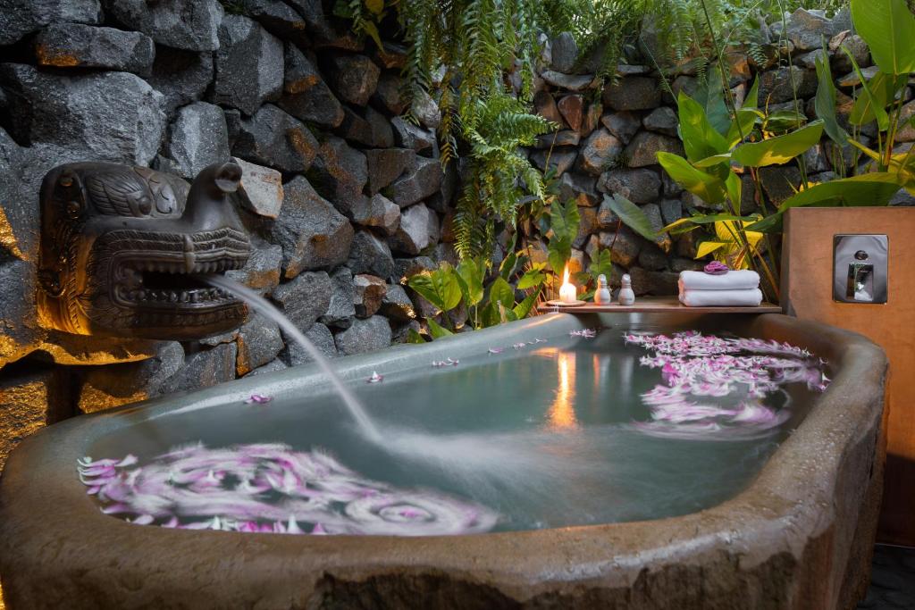 a bath tub with a fountain in a garden at Lynnaya Urban River Resort in Siem Reap