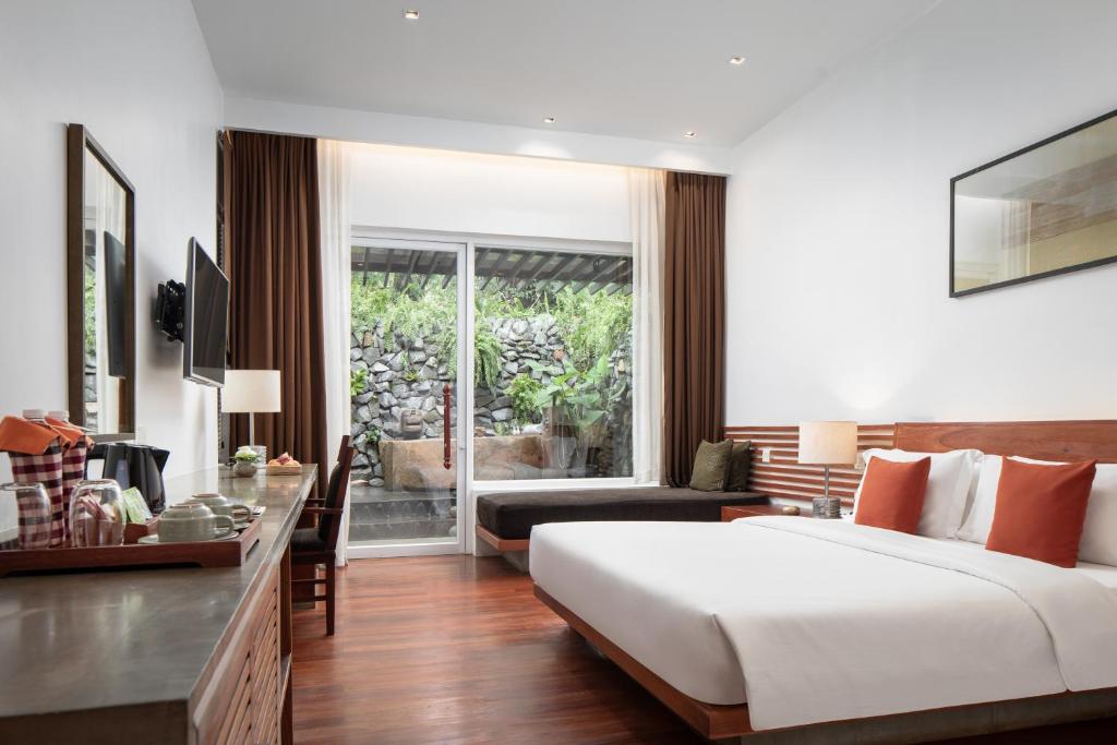 a hotel room with a bed and a desk and a room at Lynnaya Urban River Resort in Siem Reap