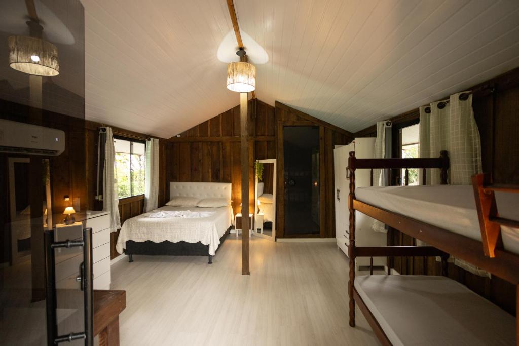a bedroom with a bed in a room with wooden walls at Casa Alegria da Ilha in Paranaguá