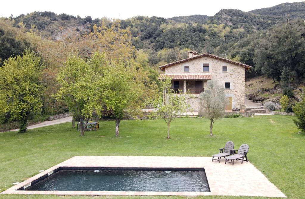 a house with a pool of water in a yard at La Xiquella, formatges artesans i masoveria in Bas