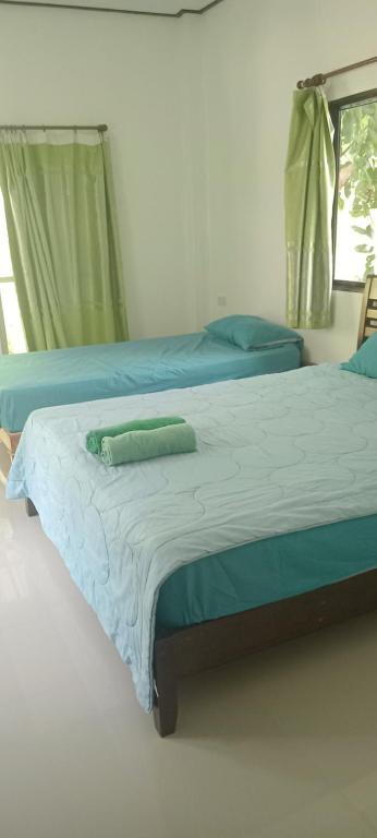 クッド島にあるChom Suan Farmstayのベッドルーム1室(青いシーツと窓付きのベッド2台付)