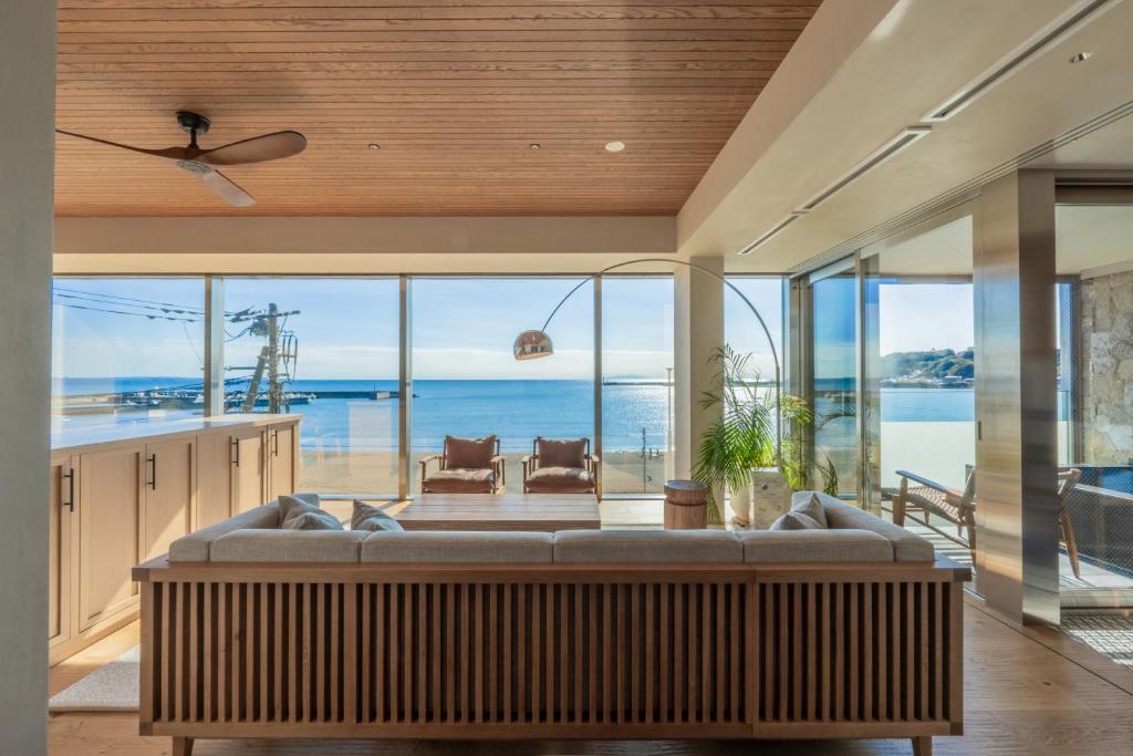 a living room with a couch and a view of the ocean at UMITO Kamakura Koshigoe in Kamakura