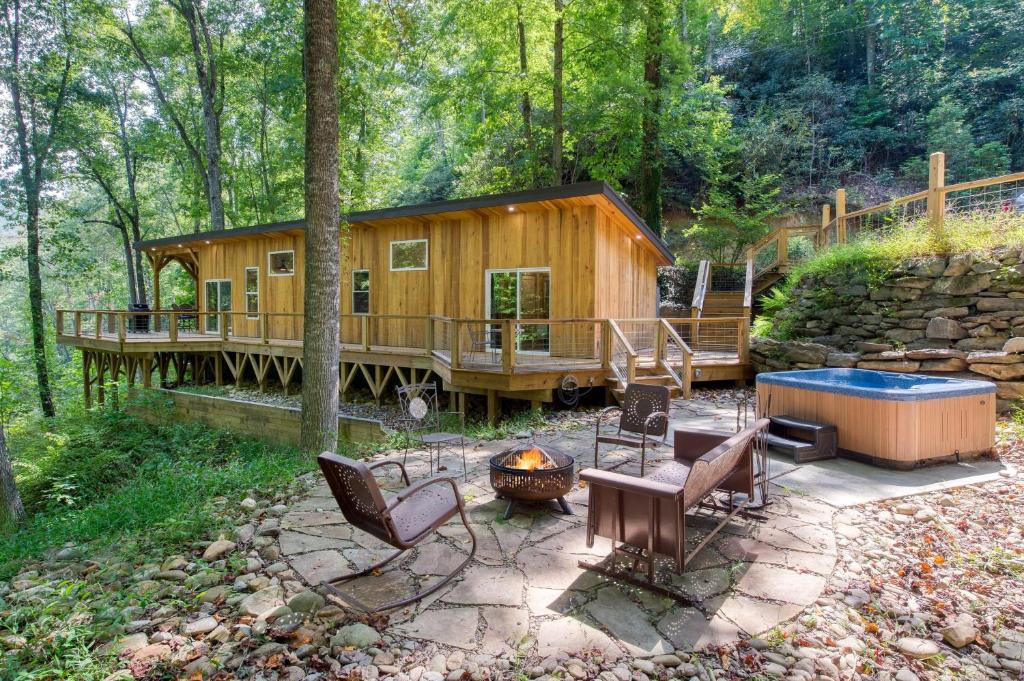 a cabin in the woods with chairs and a fire pit at Artist’s Palette by AvantStay Colorful Retreat in Fairview