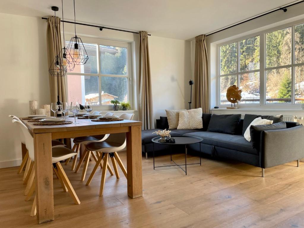 salon z niebieską kanapą i stołem w obiekcie Haigis Lodge w mieście Annaberg im Lammertal