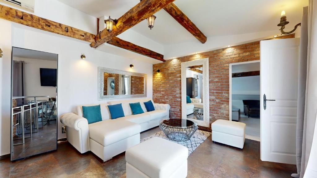 a living room with a white couch and a brick wall at Bluestay 201 - Superb apartment in Paris in Paris