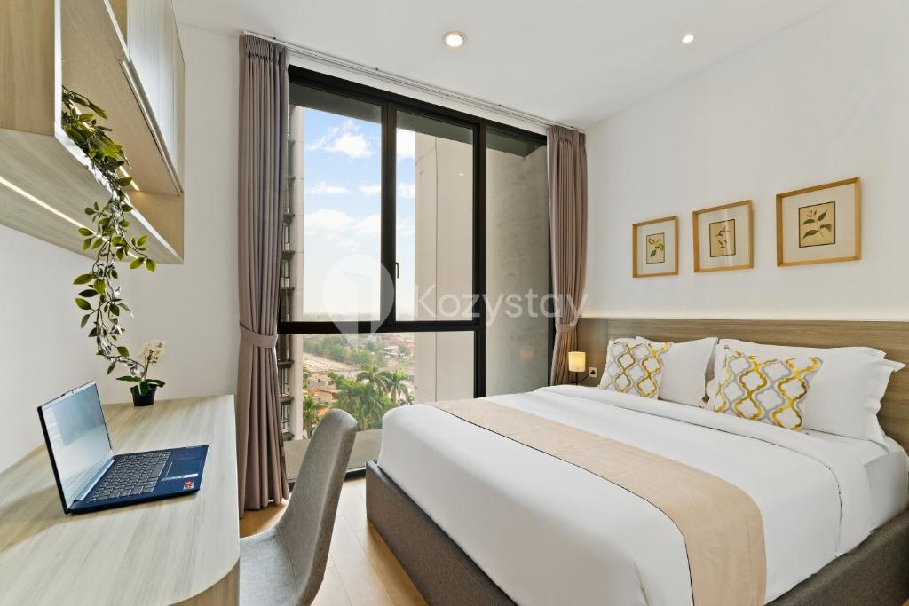 a bedroom with a bed and a laptop on a desk at Inara by Kozystay - Cilandak in Jakarta