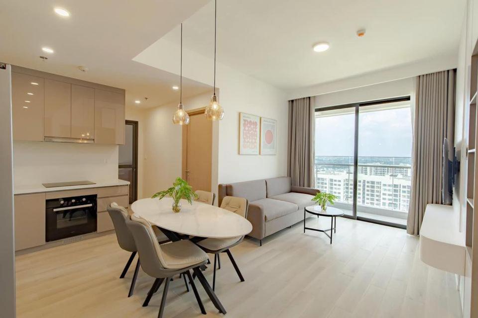 a kitchen and living room with a table and a couch at Bống Homestay-Luxury Apartment-2PN in Long Bình