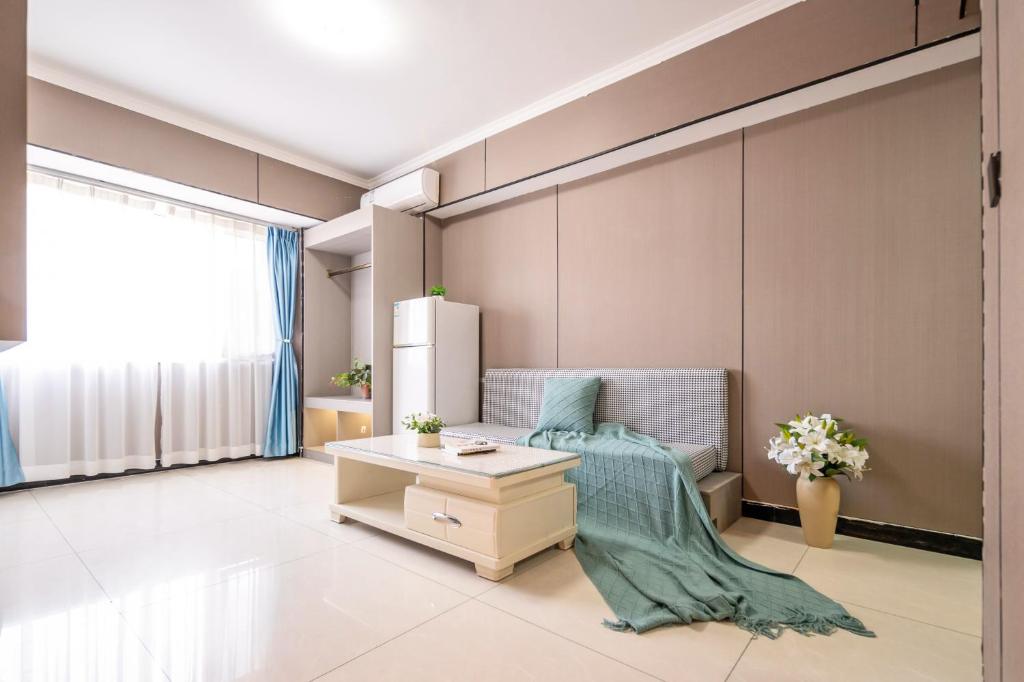 西安Xi'an Yongning Apartment Hotel的配有冰箱和桌子的客厅