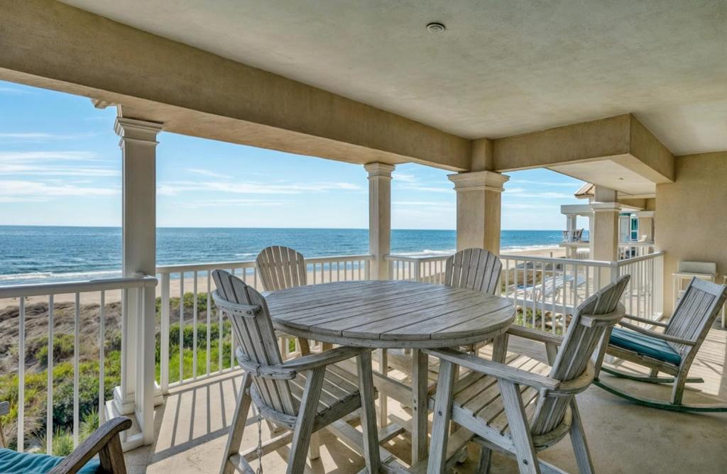 un tavolo e delle sedie su un balcone con vista sull'oceano di 301 Ocean Palms by AvantStay Ocean Front Home w Amazing Sea Views a Isle of Palms