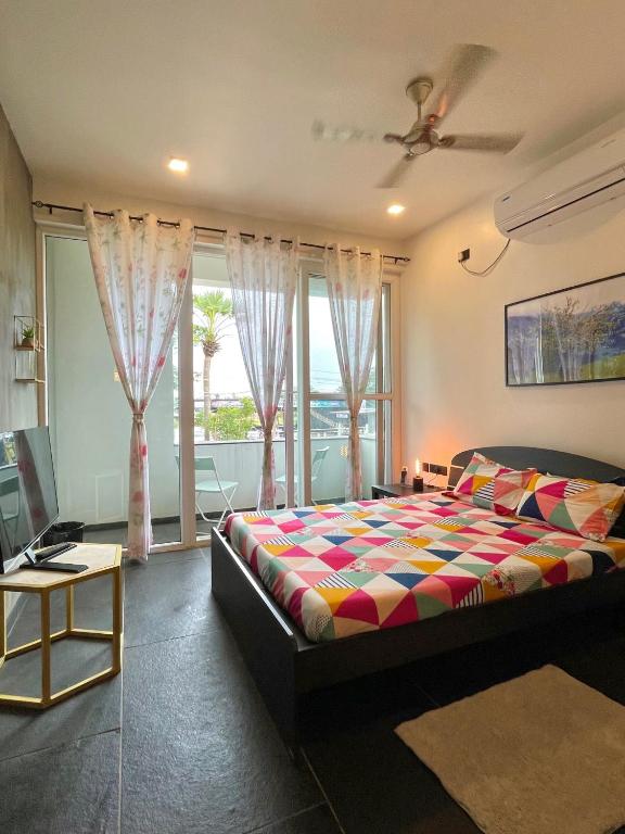 a bedroom with a bed and a large window at Six Boutique Collection in Mannārgudi