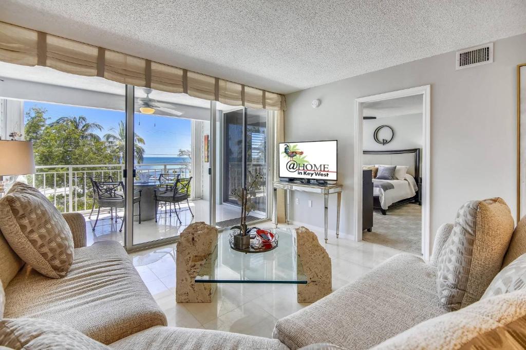 a living room with a couch and a glass table at Dune Wind South by AvantStay Communal Pool Hot Tub Gated Community Close to Smathers Beach Month Long Stays Only in Key West