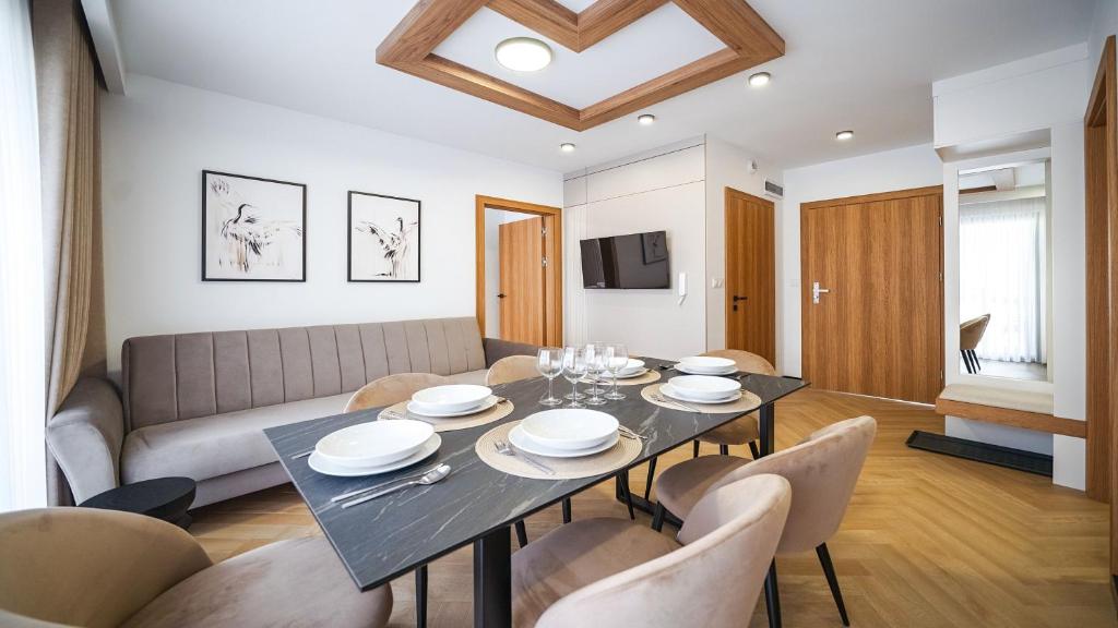 ein Wohnzimmer mit Tisch und Couch in der Unterkunft Resorts P Białka Tatrzańska z sauną, Sun & Snow in Białka Tatrzańska