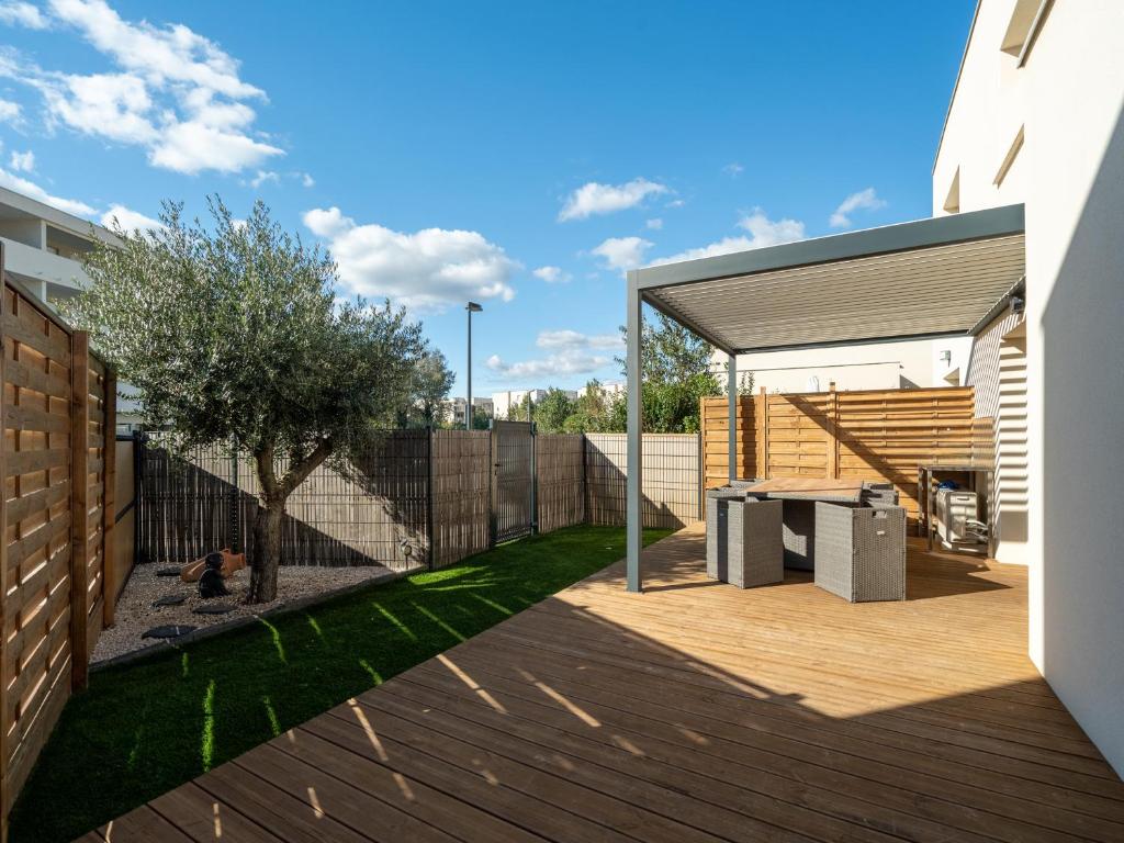 une arrière-cour avec une terrasse en bois et une maison dans l'établissement La Dune 42 - Villa 5P8, à Sérignan