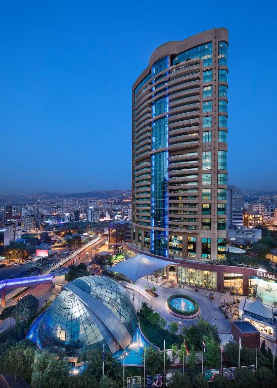 a tall building with a large glass dome next to a building at Al Habtoor Grand Beirut in Beirut