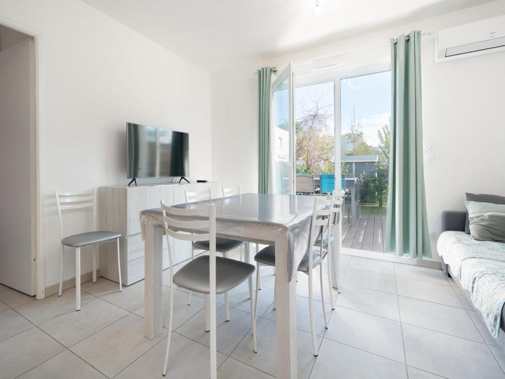une salle à manger blanche avec une table et des chaises dans l'établissement La Dune 68 - VILLA 4P8, à Sérignan
