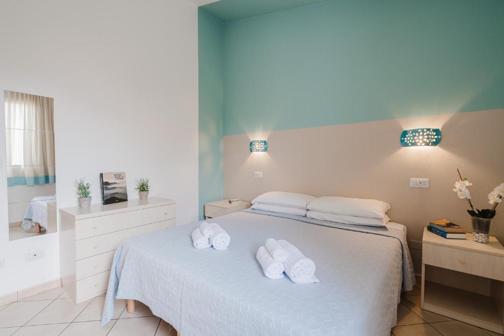 Un dormitorio con una cama con toallas blancas. en Il Melo Residence, en Porto Torres
